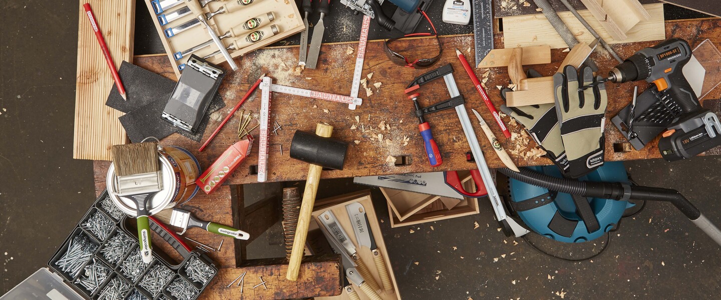 Viele verschiedene Holzwerkzeuge liegen auf einer Werkbank