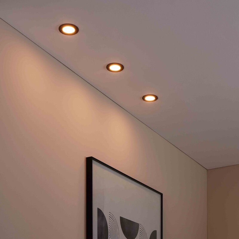 Drei Spots an einer Badezimmerdecke und ein Dekobild mit schwarz-grauem Muster an der Wand