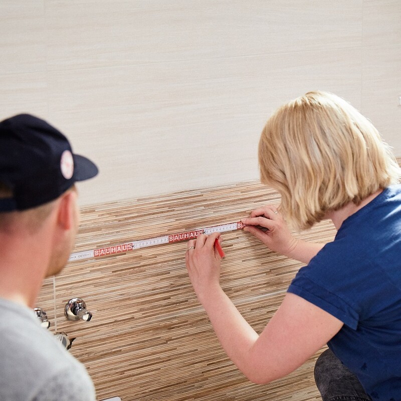 Bohrlöcher an Fliesenwand markieren
