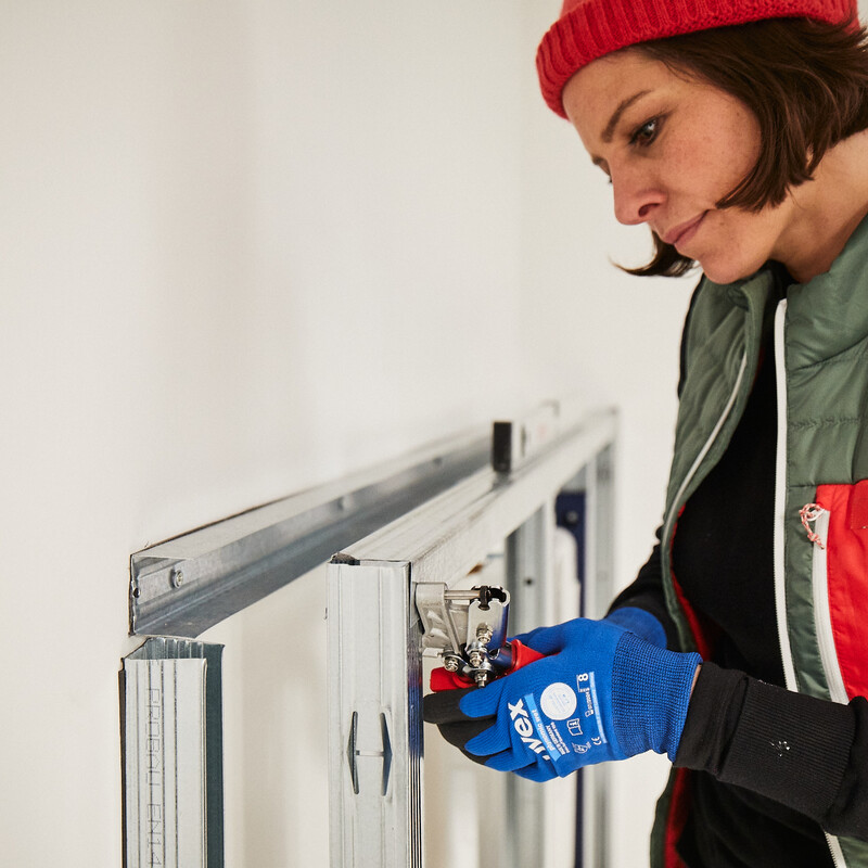 DIY WC-Vorwandinstallation: Kathi verschraubt die Alu-Profile am Spülkasten