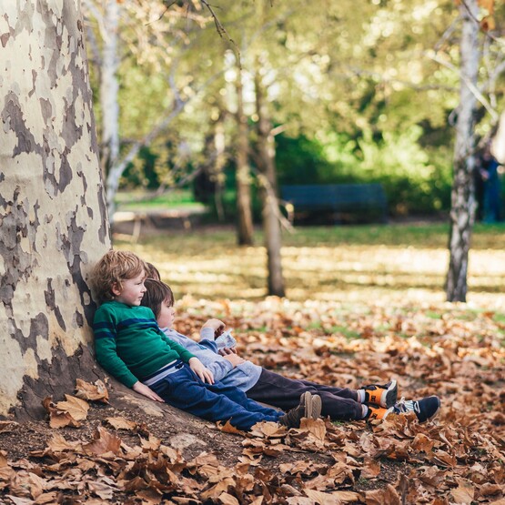 Kinder lehnen an einen Baum