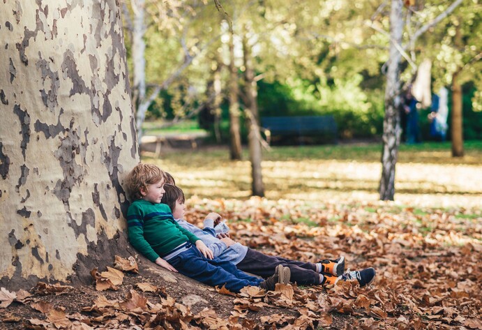 Kinder lehnen an einen Baum