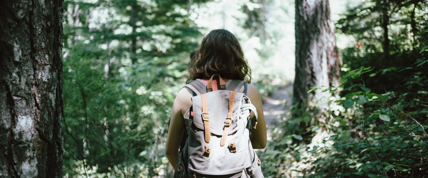 Frau wandert durch einen Wald