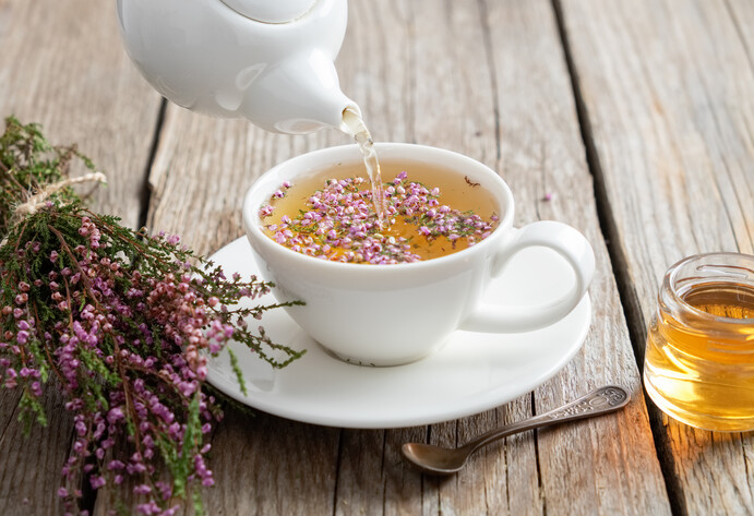 Heidekrauttee wird in Tasse gegossen