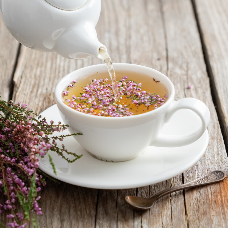 Heidekrauttee wird in Tasse gegossen