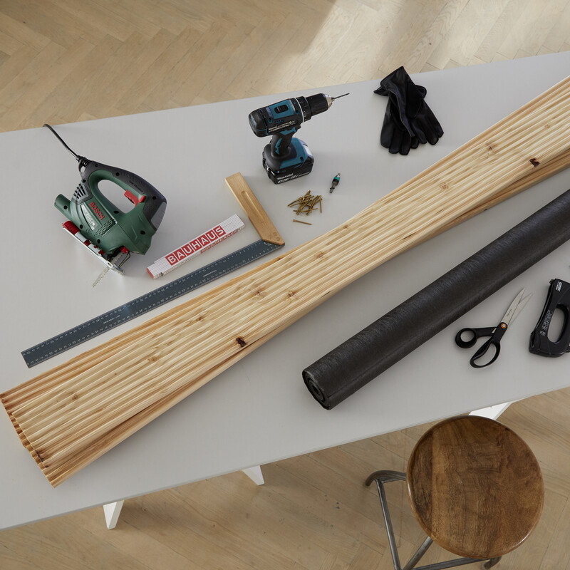 Mehrere Werkzeuge und ein paar Holzlatten liegen auf einem Tisch