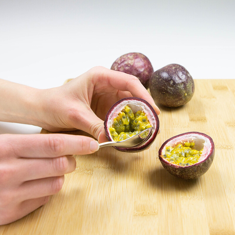 Kerne werden mit Löffel aus der Passionsfrucht entnommen