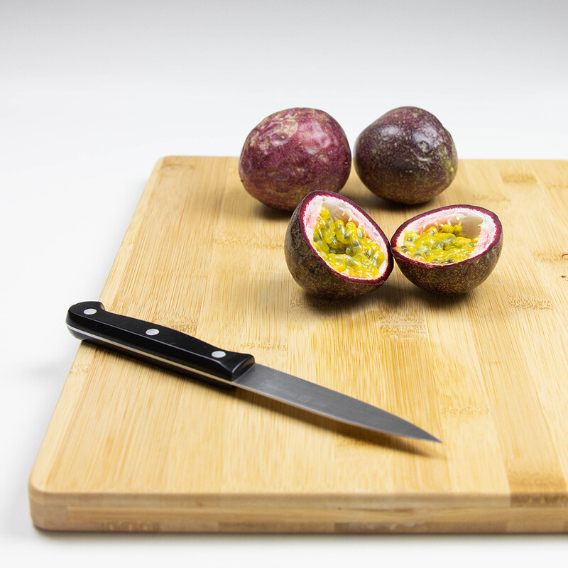 Passionsfrüchte und Messer auf Holzbrett