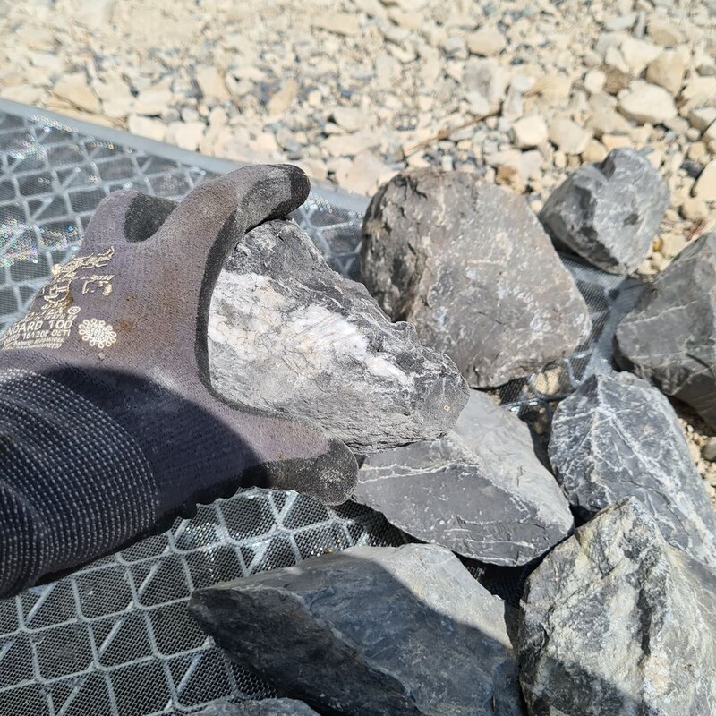 Steine zur Befestigung auf das Rost legen
