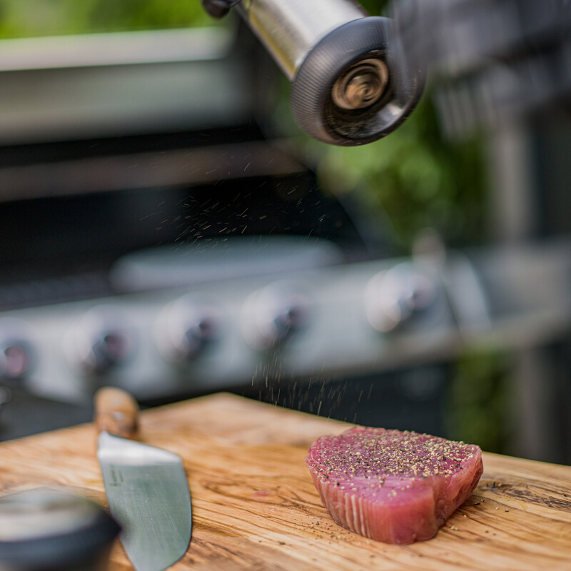 Thunfischsteak wird mit Pfeffer gewürzt