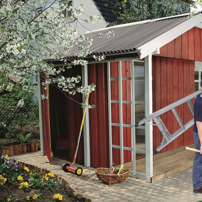 Mann mit Leiter steht vor Gartenhaus