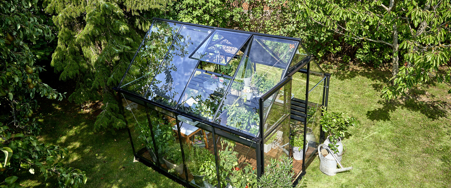 Glasgewächshaus in Garten aus Vogelperspektive