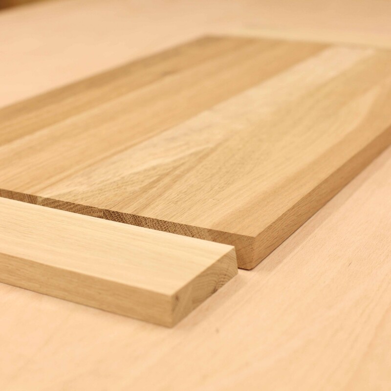 Eine schmale und eine breitete Holzplatte liegen nebeneinander