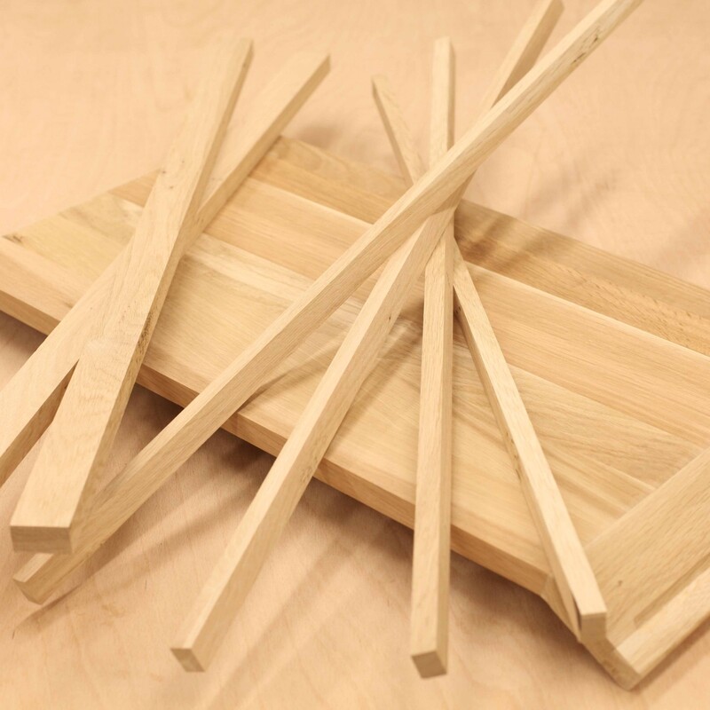 Mehrere Kanthölzer liegen auf einer Holzplatte