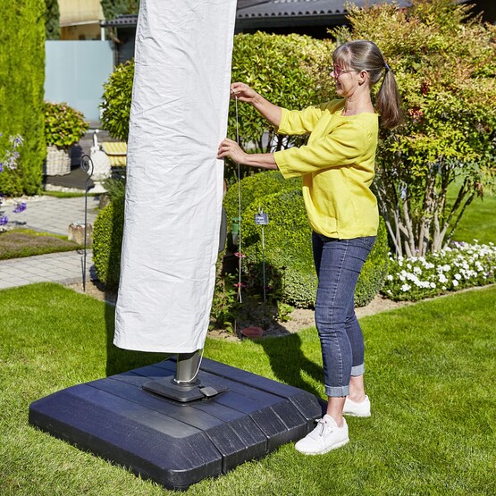 Frau macht Schutzhülle über Sonnenschirm
