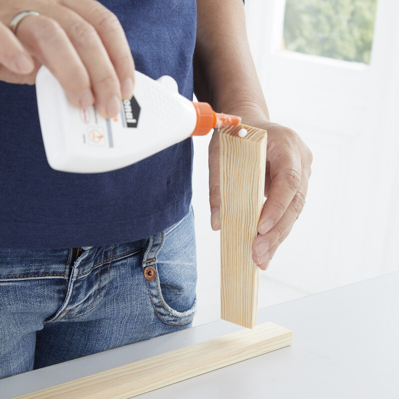 Holzleim wird auf ein Stück Holz aufgetragen