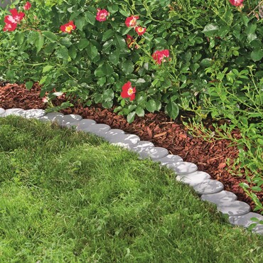 Palisaden-Randsteine als Grenze zwischen Blumenbeet und Rasen
