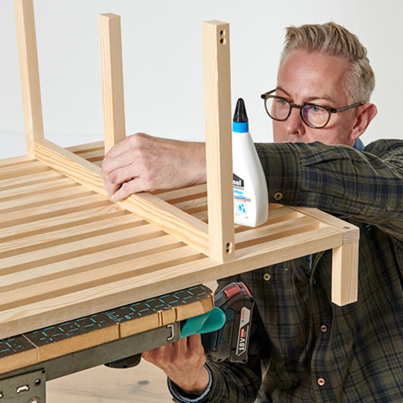 Mann mit Brille verschraubt Holzleisten