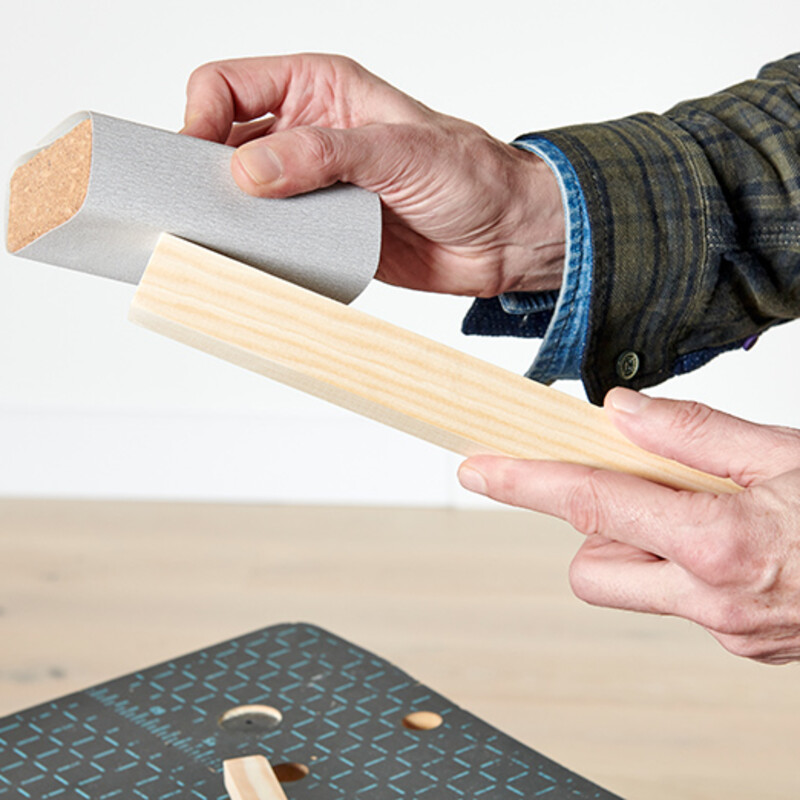 Holz wird mit Schleifpapier geglättet
