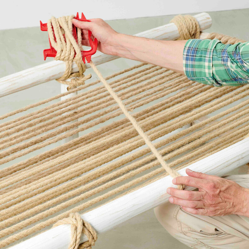 Mann spannt Seil für die Liegefläche eines selbstgebauten Daybeds