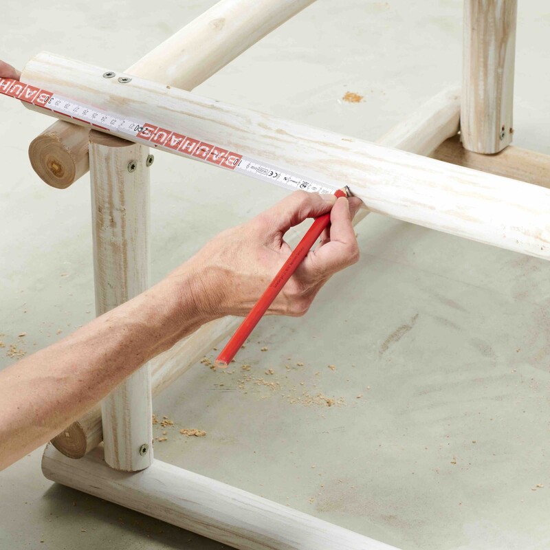 Mann markiert mit Zollstock am Daybed-Rahmen