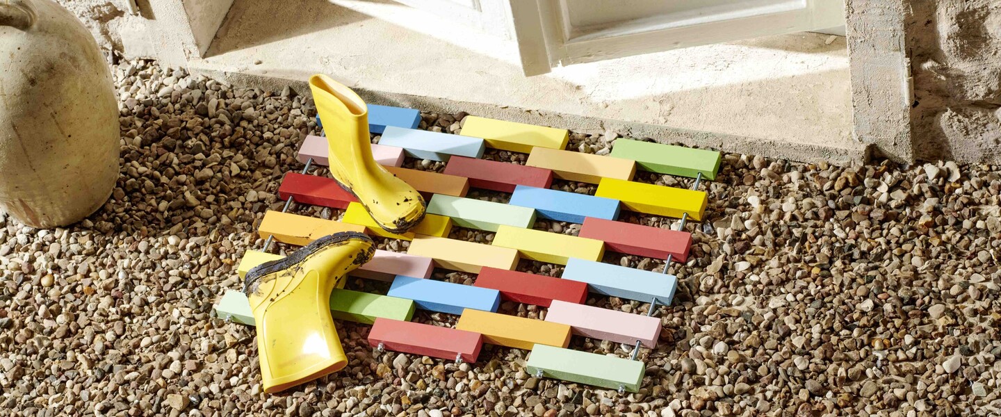 Gelbe Gummistiefel auf fertiger DIY-Fußmatte