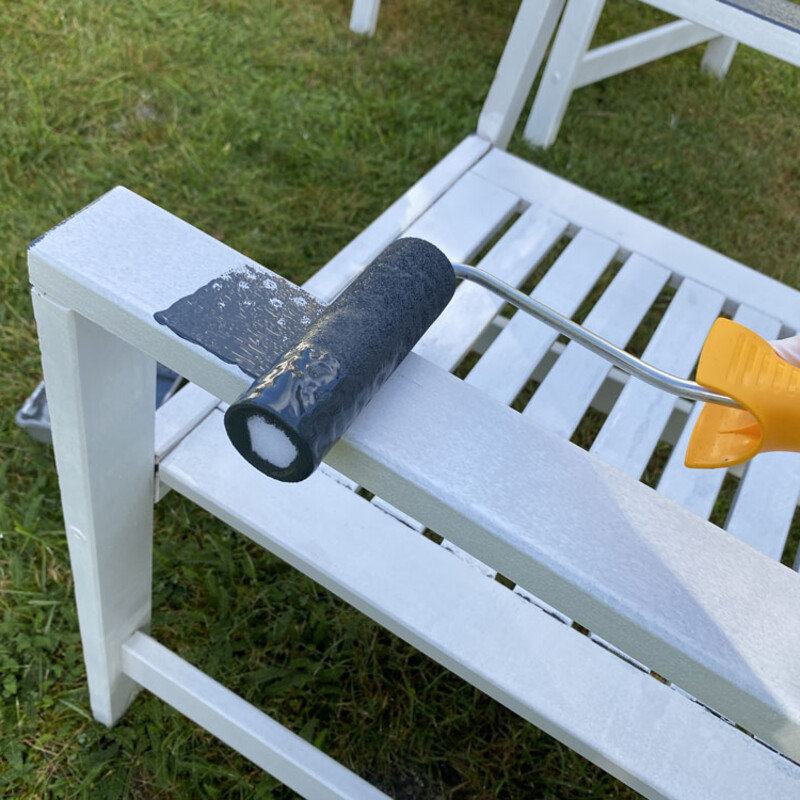 Gartenstuhl mit Malerrolle streichen