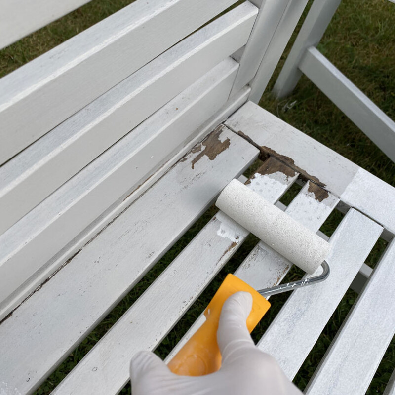 Alten Gartenstuhl mit Malerrolle vorstreichen