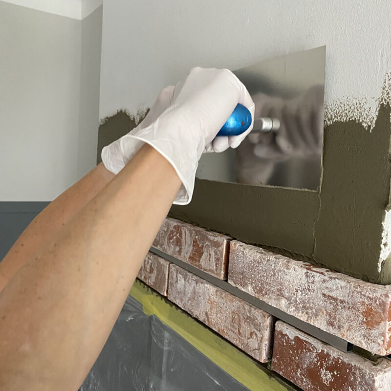 Kleber aufbringen für das Verblenden einer Wand mit Klinkersteinen