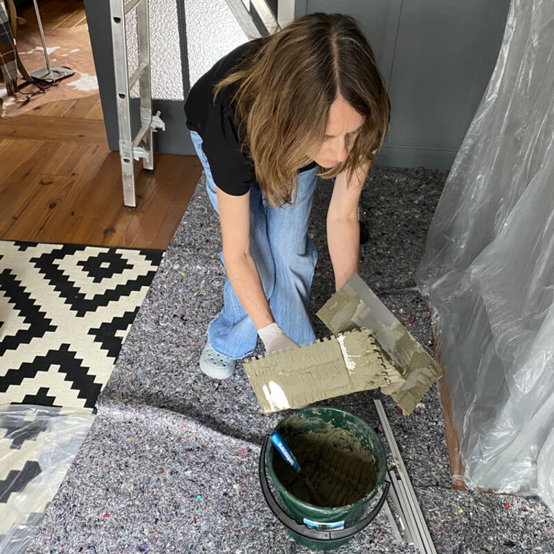 Weibliche Person bedeckt Boden und Wand mit Schutzfolie