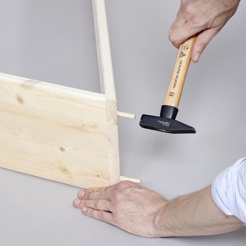 Holzstifte in die Bretter hammern