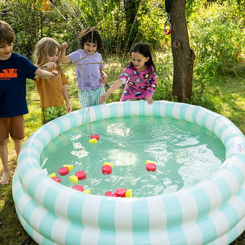 Kinder spielen Fische angeln am Planschbecken im Garten