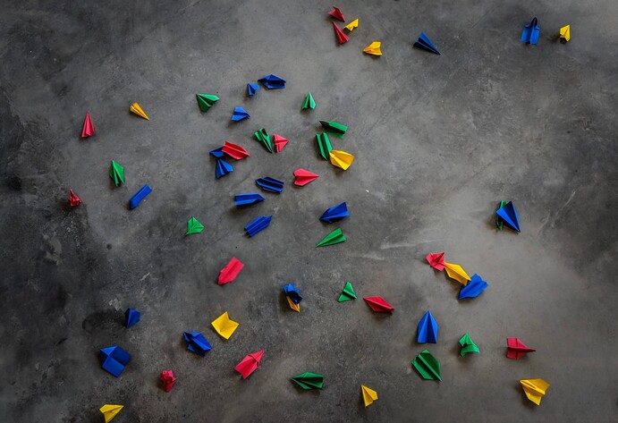 Bunte Papierflieger auf Fu&szlig;boden