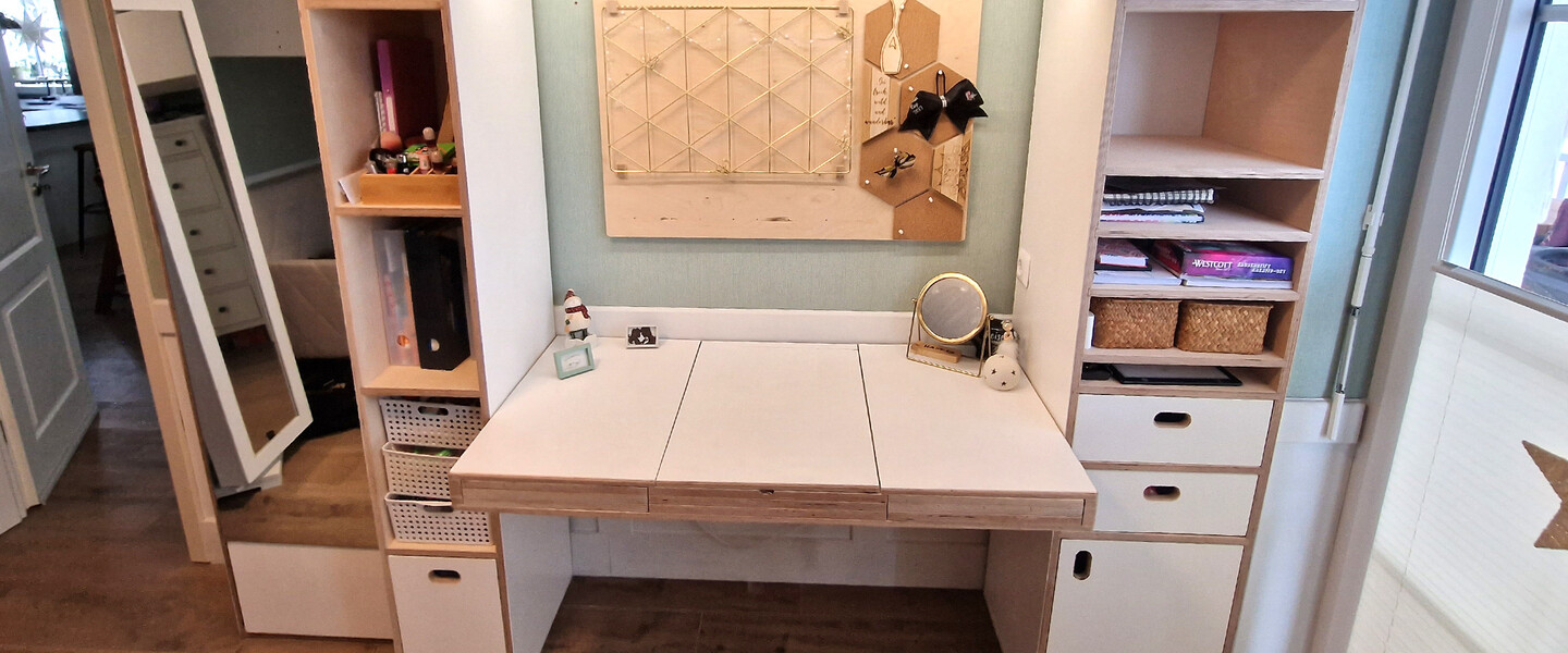 Ein selbstgebauter Schreibtisch mit weißen Fronten im Kinderzimmer