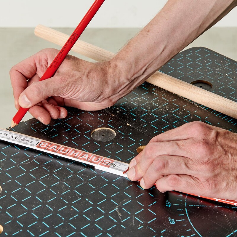 Mann markiert mit Bleistift und Zollstock