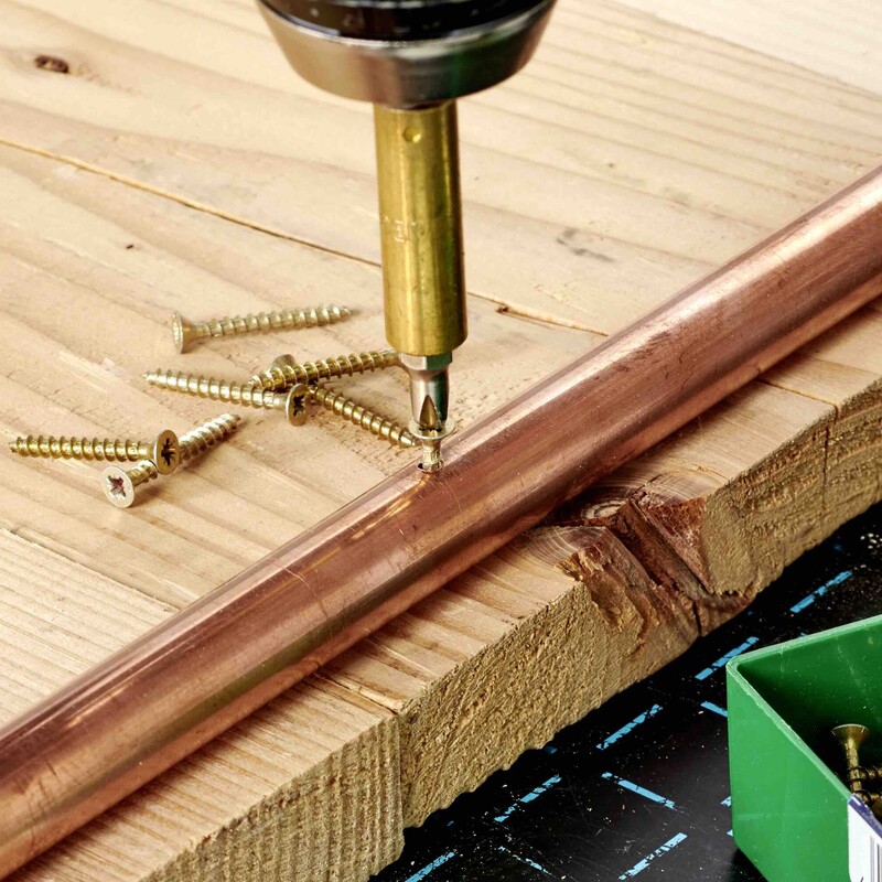 Schraube durch Kupfer und Holz drehen