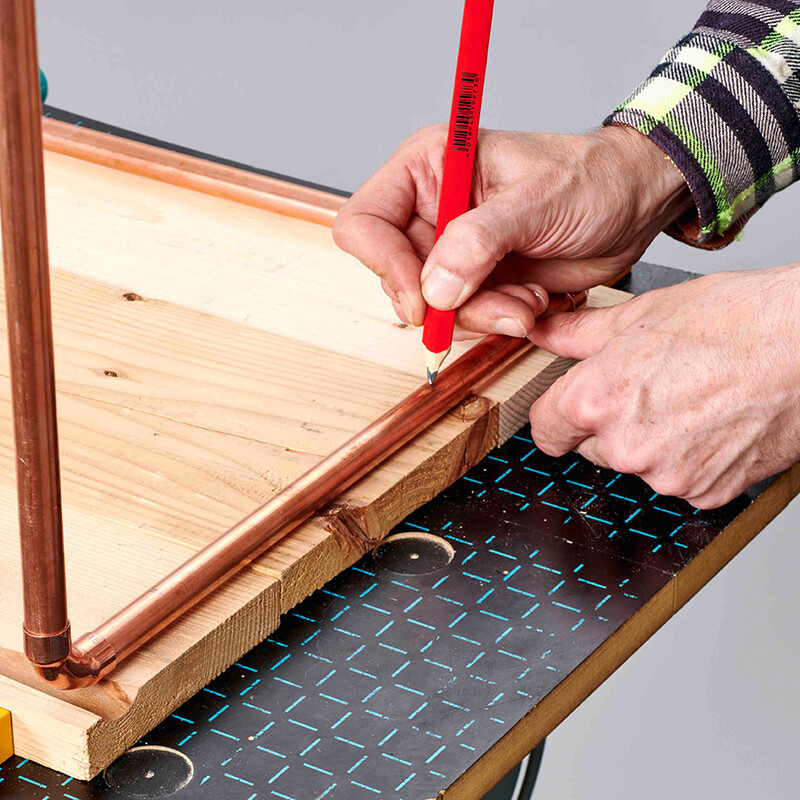 Bohrlöcher mit Bleistift auf Kupferrohr angezeichnet