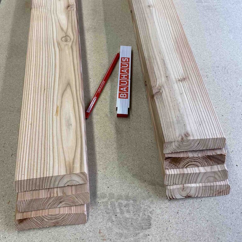 Holzleisten, Gliedermaßstab und Bleistift liegen auf Tisch