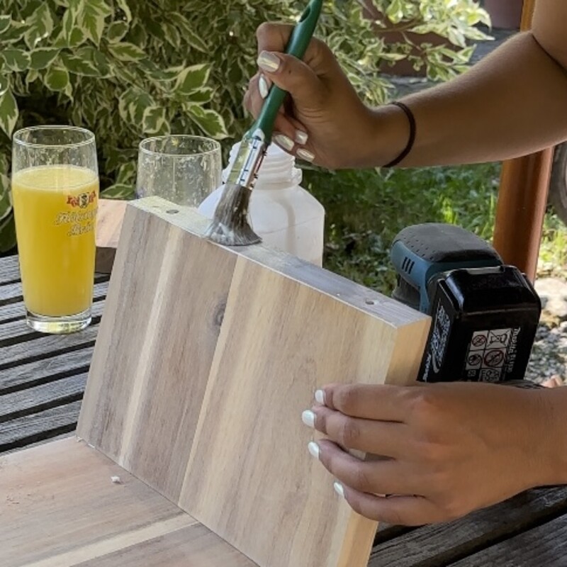 Kante eines Holzbrettes mit Holzleim bestreichen