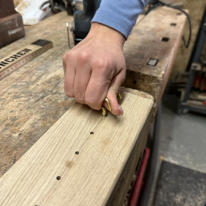 Eindrehen von Haken in Holzbrett