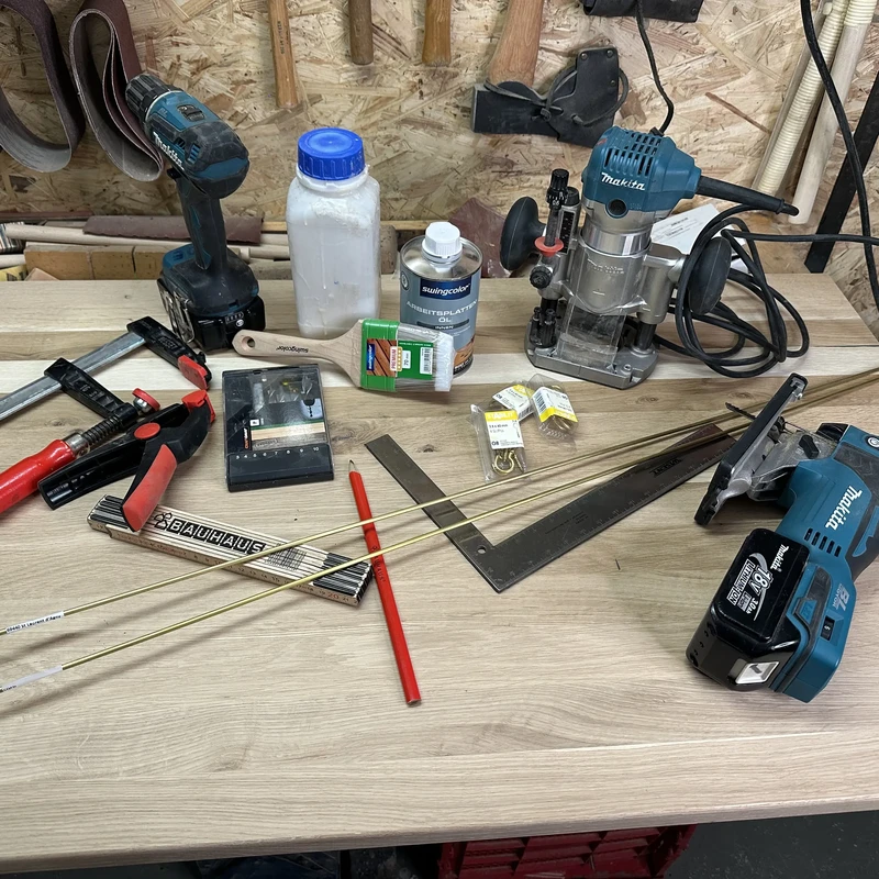 Werkzeuge und Materialien für DIY Schmuckregal liegen auf Tisch in Werkstatt