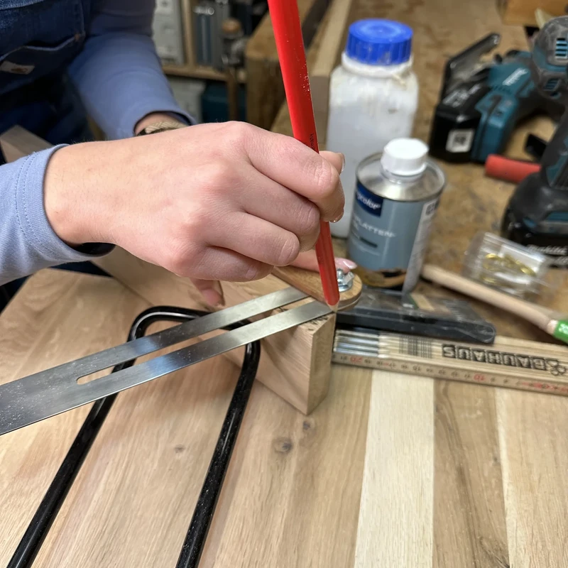 Holzstück wird mit Bleistift markiert