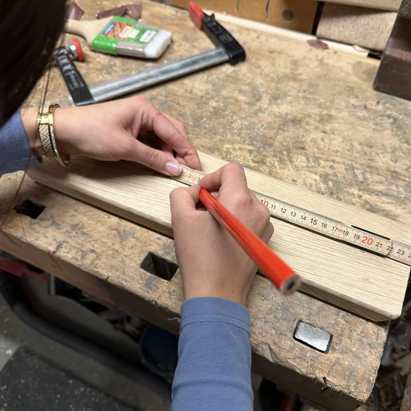 Holzstück wird mit Bleistift und Zollstpck markiert