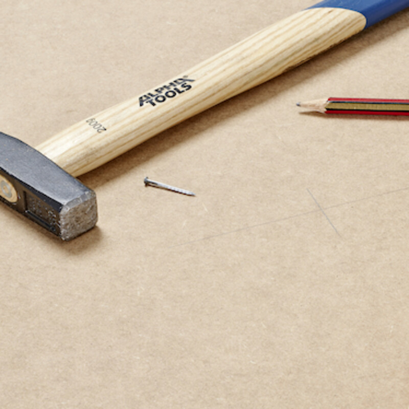Hammer, Nagel und Stift auf Holz