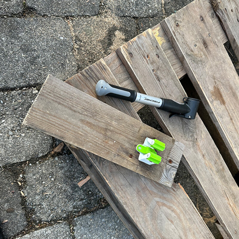 Fahrradständer aus Paletten selber bauen: Werkzeughalter montiert auf Holzstück, daneben eine Luftpumpe