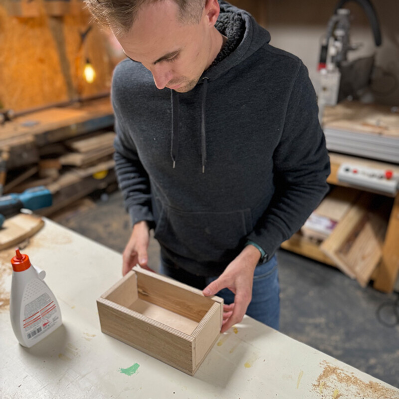 Mann baut in Werkstatt kleine Holzkiste