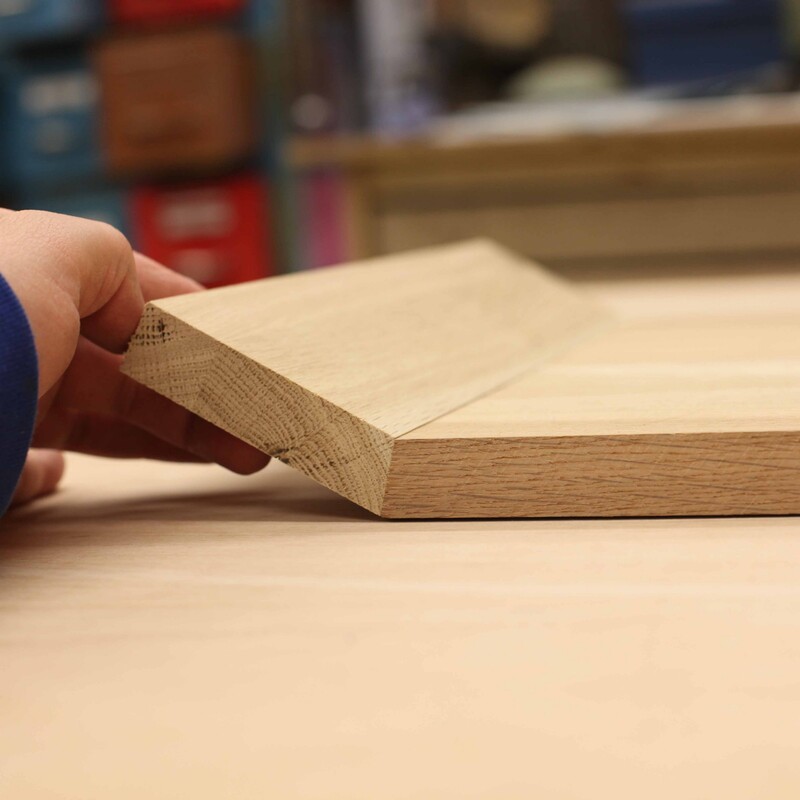 Gehrungsschnittkanten an zwei Holzst&uuml;cken werden aneinander gehalten