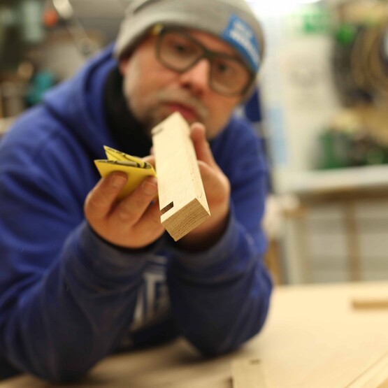 Robert Sike schleift ein Kantholz ab