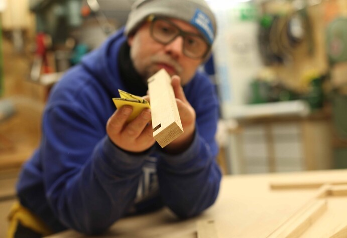 Robert Sike schleift ein Kantholz ab