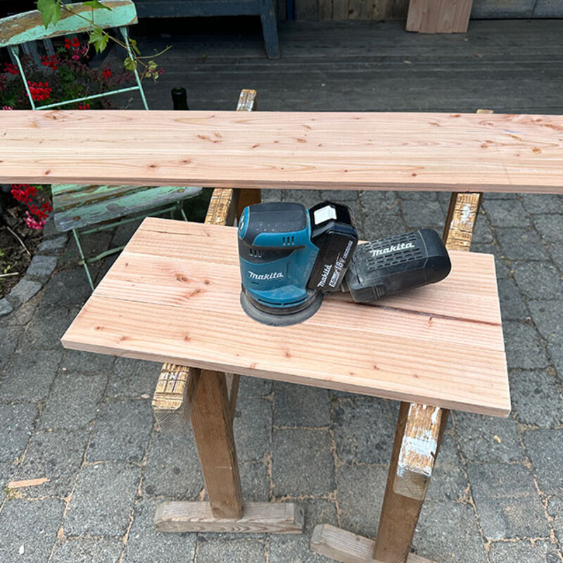 Schleifmaschine liegt auf Holzbrett